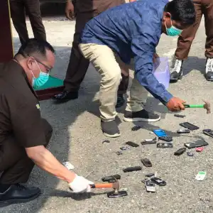 Kejari Pidie Jaya Musnahkan Barang Bukti 32 Unit HP Pakai Palu